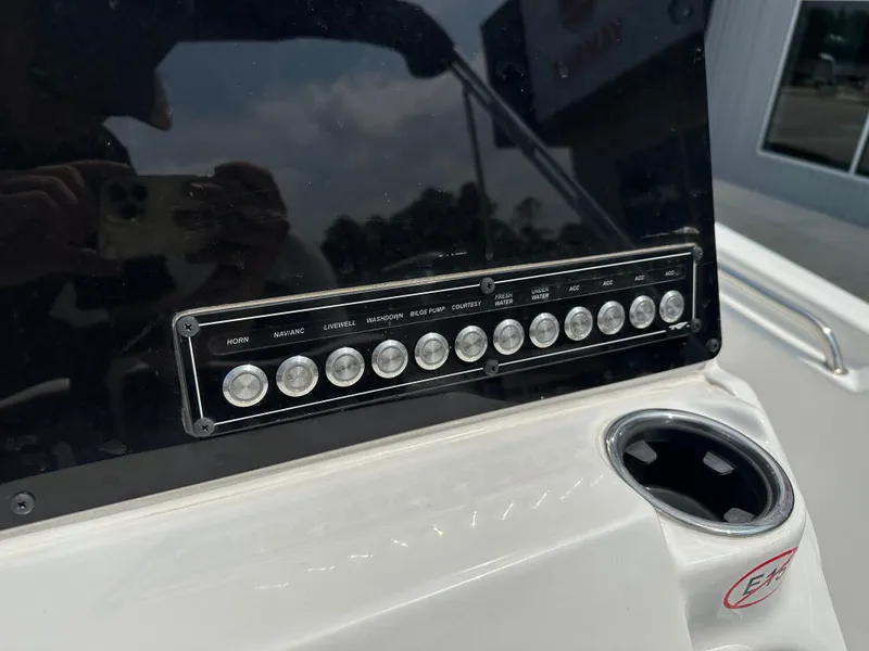Slide: The Image of Control panel of 2025 Tidewater 198CC boat with labeled switches and cup holder. - 14