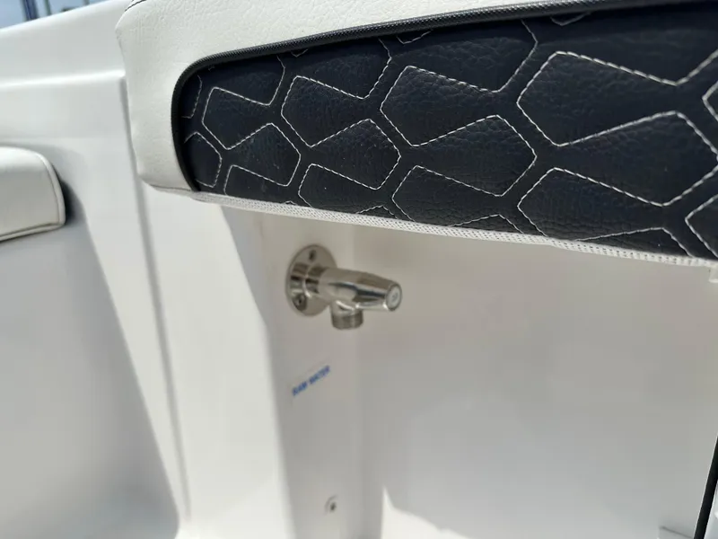 Slide: The Image of 2025 Tidewater 198CC boat interior detail with black and white upholstery and metal fixture. - 22