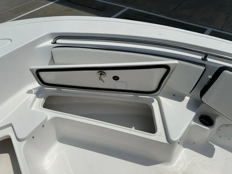 Slide: The Image of 2025 Tidewater 198CC boat storage compartment with open hatch and key. - 29