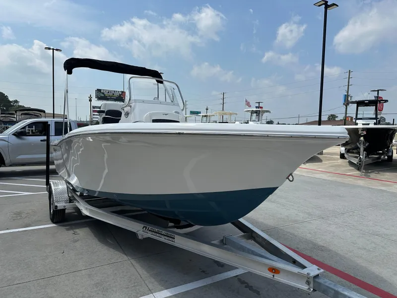 Slide: The Image of 2025 Tidewater 198CC boat on trailer in parking lot under cloudy sky. - 6