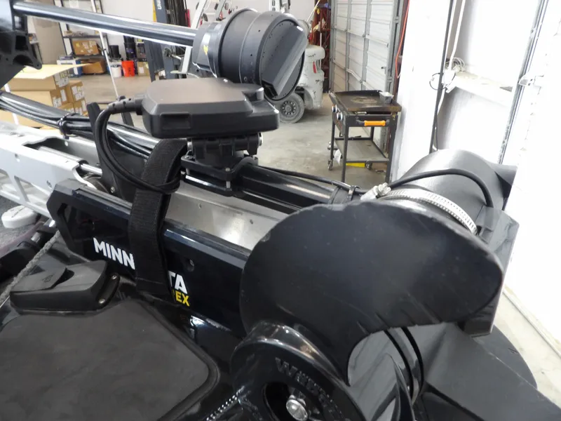 Slide: The Image of 2023 Tracker PRO190TX boat with Minn Kota trolling motor in a garage setting. - 15