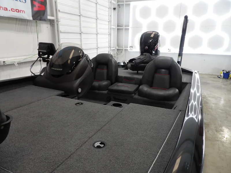 Slide: The Image of 2023 Tracker PRO190TX boat interior with seating and controls in a showroom. - 8