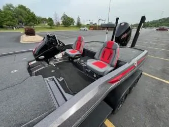 Slide: The Image of 2024 iKon LX 21 boat with red and gray seats in a parking lot. - 13