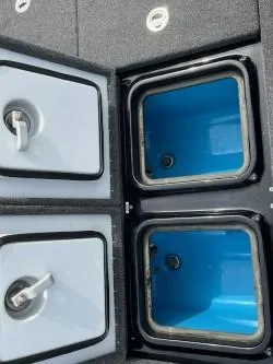 Slide: The Image of 2024 iKon LX 21 boat storage compartments with blue interior and secure latches. - 8