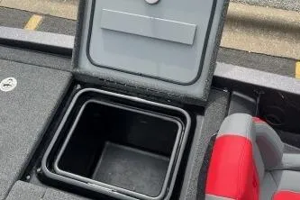 Slide: The Image of Open storage compartment in 2024 iKon LX 21 boat, featuring gray and red seating. - 9
