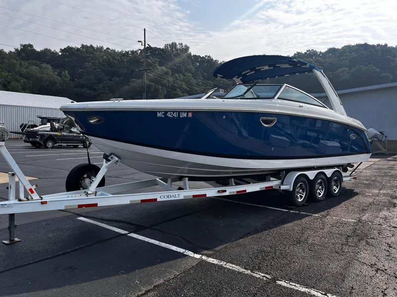 The Image of 2016 Cobalt R30 boat on trailer in parking lot, blue and white design. - 0