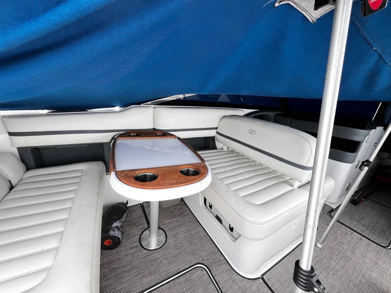 Slide: The Image of Interior of a 2016 Cobalt R30 boat with white seating and a wooden table. - 11