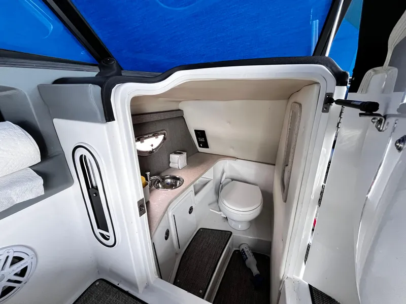 Slide: The Image of 2016 Cobalt R30 boat interior with compact bathroom, featuring a toilet and sink. - 17