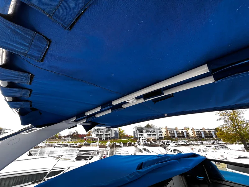 Slide: The Image of Blue canopy on 2016 Cobalt R30 boat, docked at marina with buildings in background. - 19
