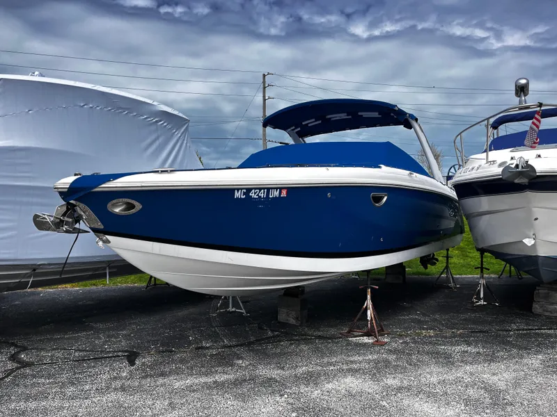 Slide: The Image of 2016 Cobalt R30 boat in blue, parked on a trailer under a cloudy sky. - 2