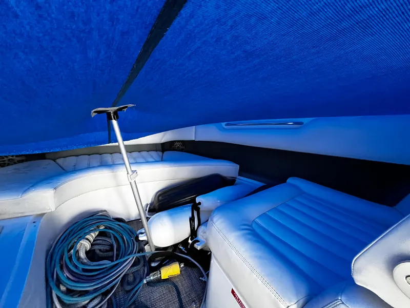 Slide: The Image of 2016 Cobalt R30 boat interior with blue cover, white seating, and coiled rope. - 20