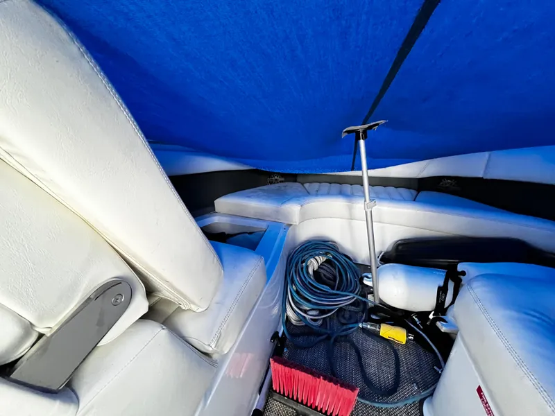 Slide: The Image of Interior of a 2016 Cobalt R30 boat with white seating and blue cover. - 21