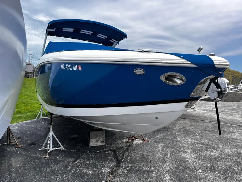 Slide: The Image of 2016 Cobalt R30 boat on stands, blue and white exterior, parked on asphalt. - 3