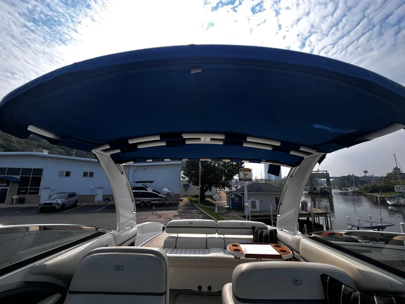 Slide: The Image of 2016 Cobalt R30 boat interior with blue canopy, docked near marina. - 46