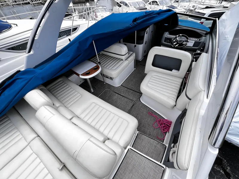 Slide: The Image of 2016 Cobalt R30 boat interior with white seating and blue cover in marina. - 8