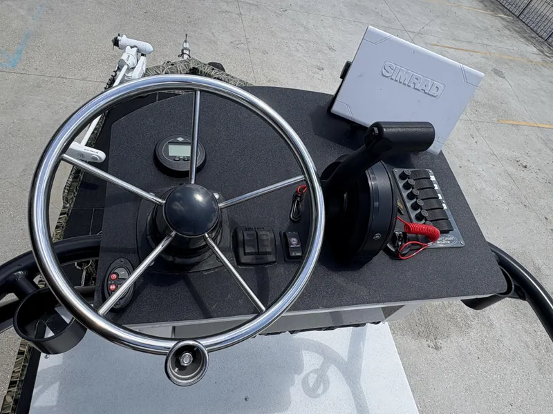 Slide: The Image of Boat console with steering wheel, Simrad device, and controls on a Prodigy 20 x 72, 2017 model. - 7