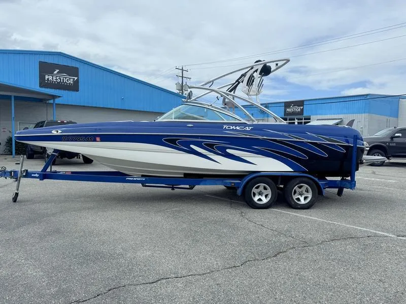 Slide: The Image of 2007 MB TOMCAT boat on trailer, blue and white design, parked outside Prestige building. - 1