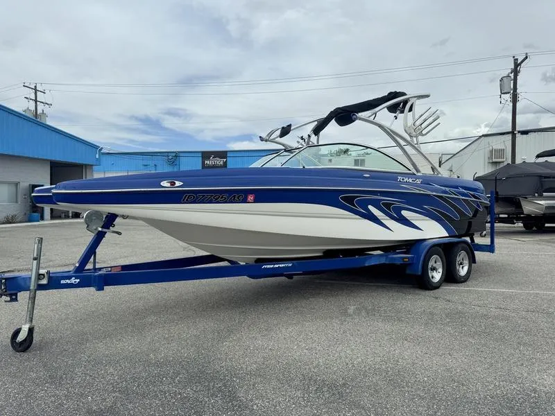 Slide: The Image of 2007 MB TOMCAT boat on trailer, blue and white design, parked outdoors. - 3