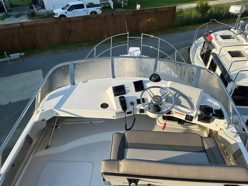 Slide: The Image of 2020 Cutwater C-32 CB boat helm with steering wheel and controls, docked outdoors. - 10