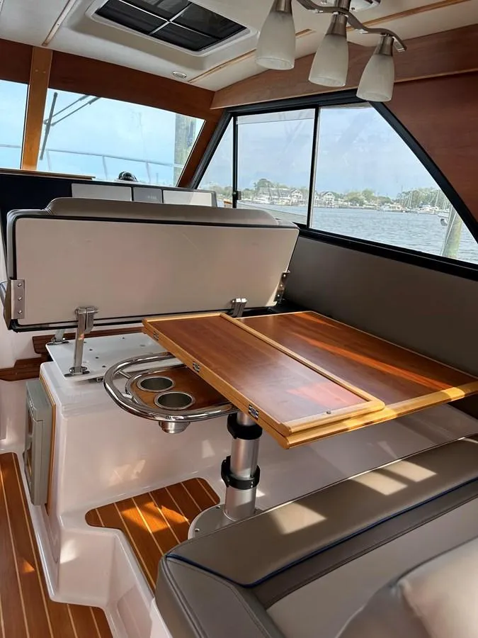 Slide: The Image of 2020 Cutwater C-32 CB interior with wooden table and seating, overlooking water view. - 17