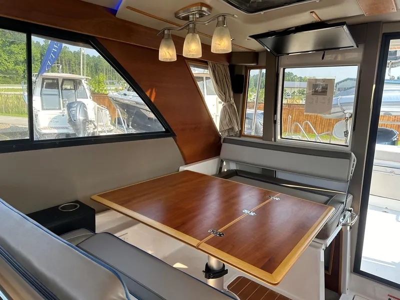 Slide: The Image of Interior of 2020 Cutwater C-32 CB boat with wooden table and seating area. - 19