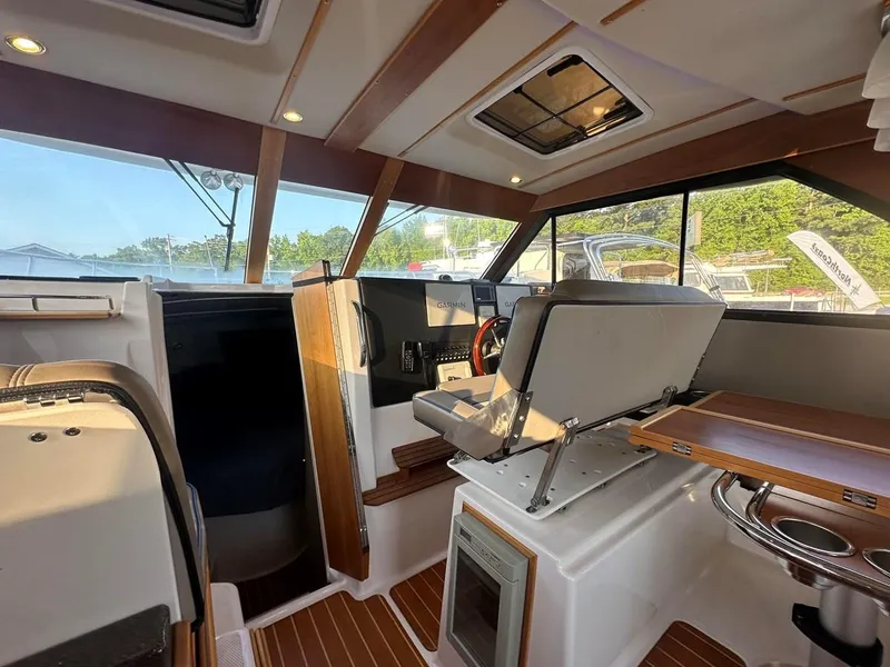 Slide: The Image of 2020 Cutwater C-32 CB boat interior with modern helm, seating, and wood accents. - 20