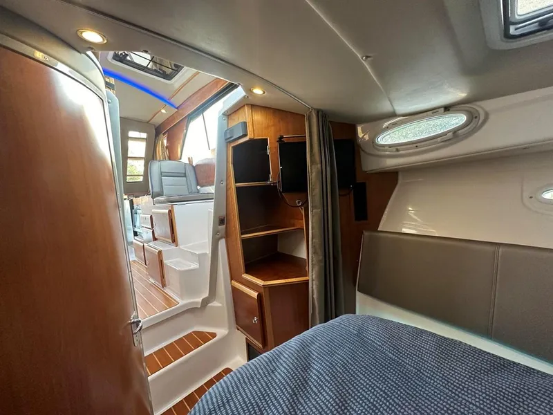 Slide: The Image of Interior of 2020 Cutwater C-32 CB boat, featuring cozy cabin and wooden accents. - 22