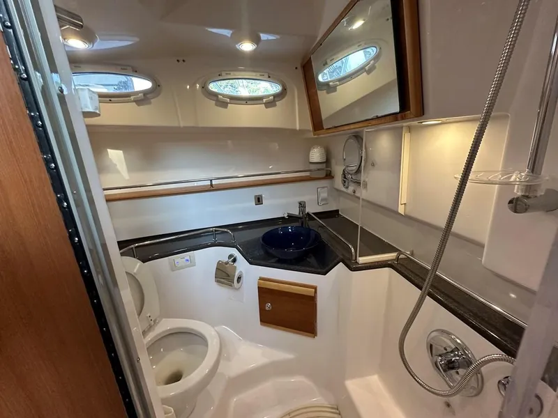 Slide: The Image of 2020 Cutwater C-32 CB boat bathroom with modern fixtures and porthole windows. - 24