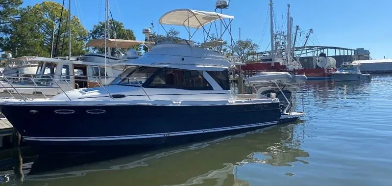 Slide: The Image of 2020 Cutwater C-32 CB boat docked in a marina under clear blue skies. - 26