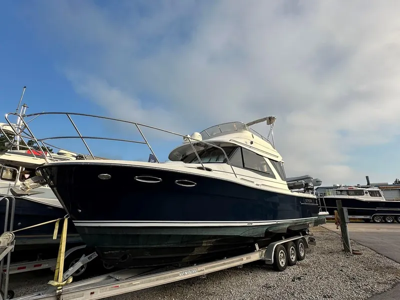 Slide: The Image of 2020 Cutwater C-32 CB boat on trailer, parked outdoors under a cloudy sky. - 4