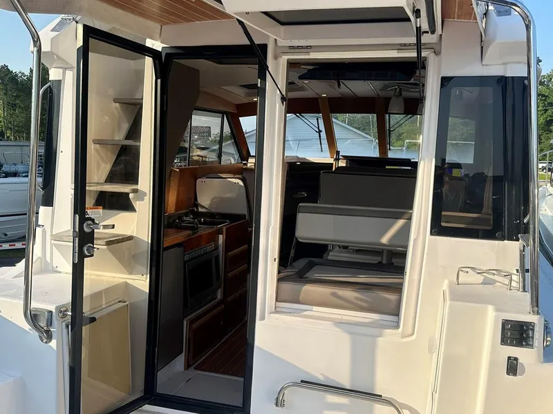 Slide: The Image of 2020 Cutwater C-32 CB boat interior with open door, showcasing seating and kitchen area. - 9