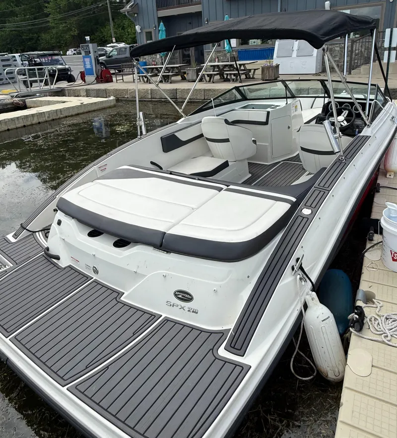 Slide: The Image of 2018 Sea Ray SPX 210 boat docked, featuring sleek design and spacious seating. - 3