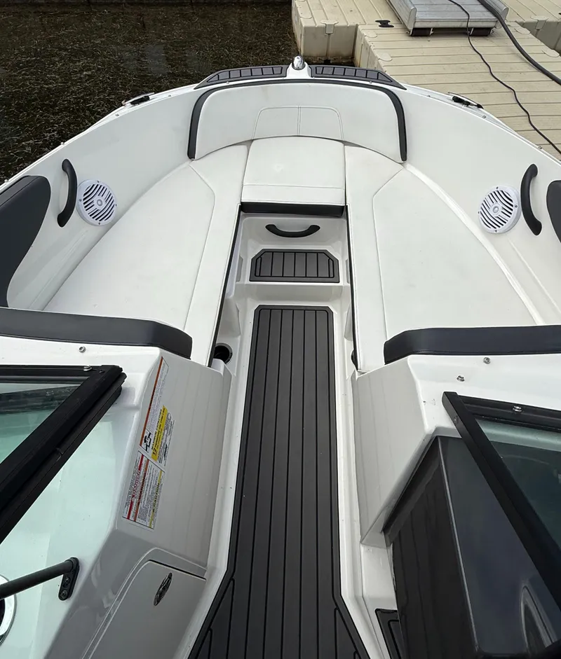 Slide: The Image of 2018 Sea Ray SPX 210 boat interior with white seating and black flooring. - 8