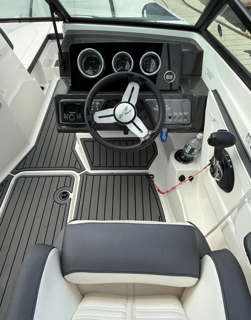 Slide: The Image of 2018 Sea Ray SPX 210 boat cockpit with steering wheel and dashboard controls. - 9