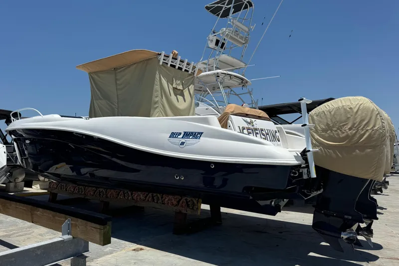 The Image of 2010 Deep Impact 36 DI boat on trailer, docked under clear blue sky. - 0