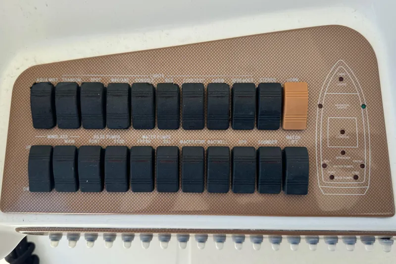 Slide: The Image of Control panel of a 2010 Deep Impact 36 DI boat with multiple switches. - 14