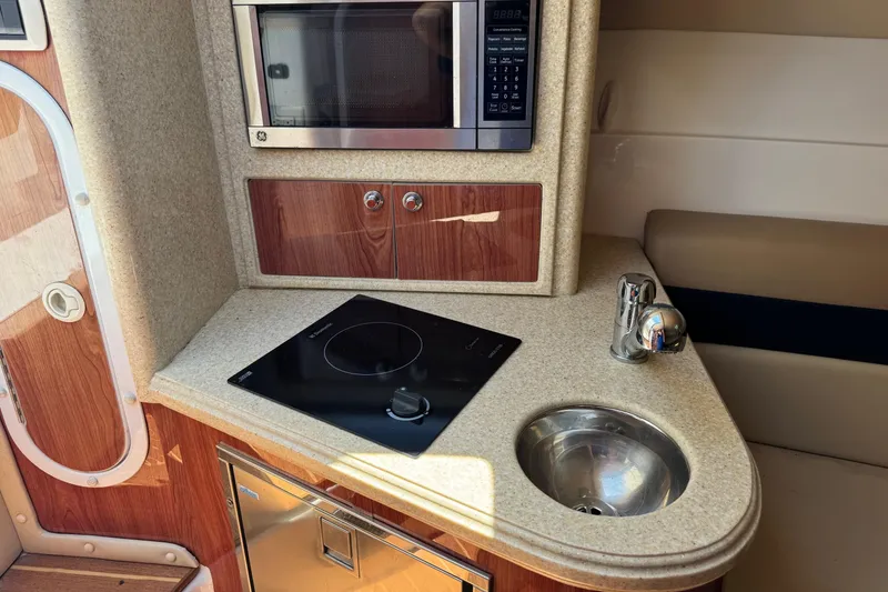 Slide: The Image of Compact kitchen area in a 2010 Deep Impact 36 DI boat with stove, sink, and microwave. - 28