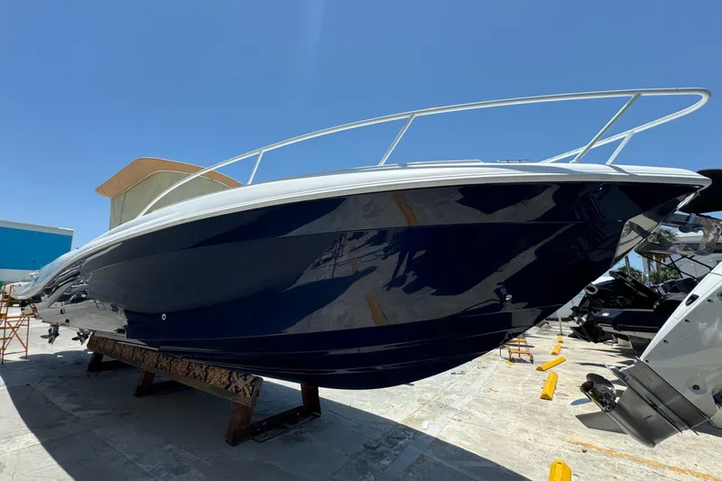 Slide: The Image of 2010 Deep Impact 36 DI boat with sleek blue hull, docked under clear sky. - 44