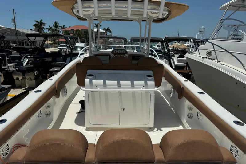 Slide: The Image of 2010 Deep Impact 36 DI boat interior with seating and control panel, docked among other boats. - 6