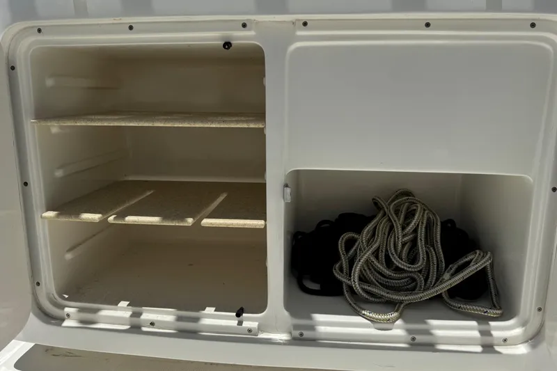 Slide: The Image of Storage compartment on a 2010 Deep Impact 36 DI boat with shelves and coiled rope. - 9