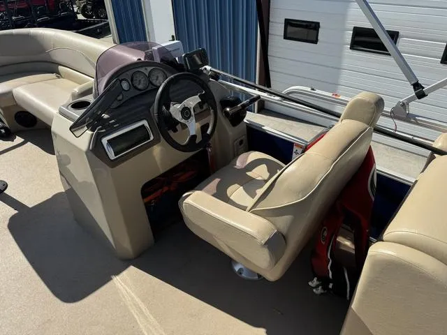 Slide: The Image of 2014 SunCatcher V322 RC boat interior with steering console and beige seating. - 10