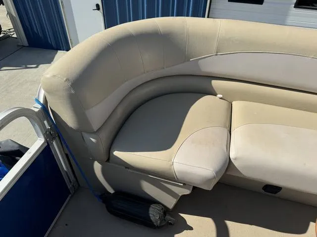 Slide: The Image of 2014 SunCatcher V322 RC boat with beige seating, docked near blue storage units. - 29