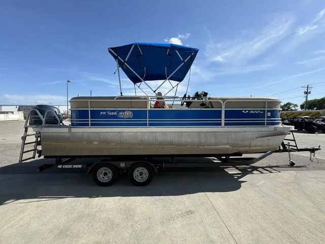 Slide: The Image of 2014 SunCatcher V322 RC pontoon boat on trailer with blue canopy, parked outdoors. - 5