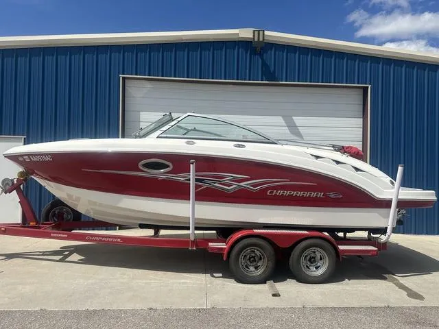 Slide: The Image of 2008 Chaparral Sunesta 224 boat on trailer, parked outside blue garage. - 1