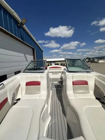 Slide: The Image of 2008 Chaparral Sunesta 224 boat with white and red seating, docked under a clear blue sky. - 21