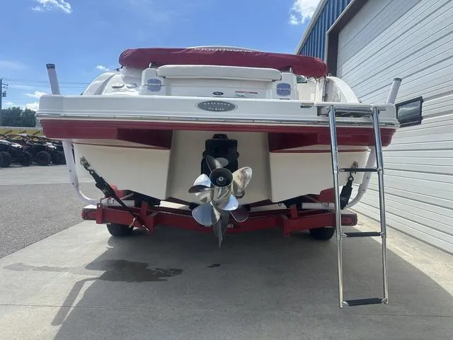 Slide: The Image of 2008 Chaparral Sunesta 224 boat rear view with ladder and propeller, parked near a garage. - 7