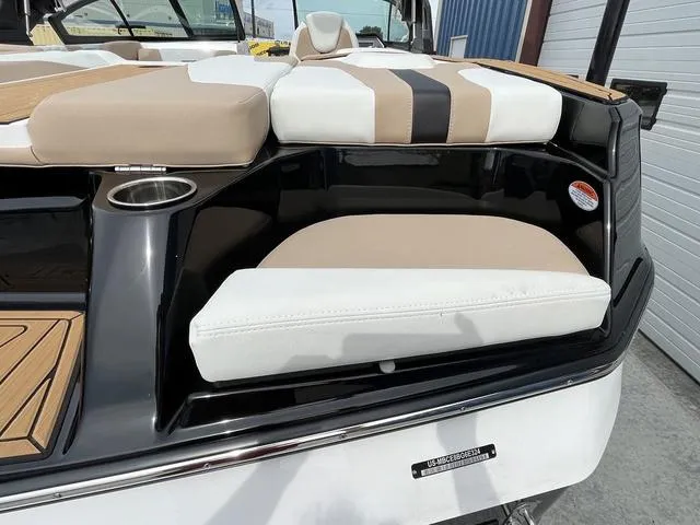 Slide: The Image of 2024 MasterCraft XT20 boat interior with beige and white seating, cup holder, and sleek design. - 13
