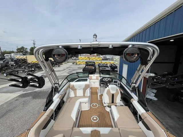 Slide: The Image of 2024 MasterCraft XT20 boat interior with sleek seating and modern design at a dealership. - 16