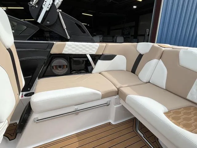 Slide: The Image of 2024 MasterCraft XT20 boat interior with beige and white seating, featuring modern design and speaker system. - 22