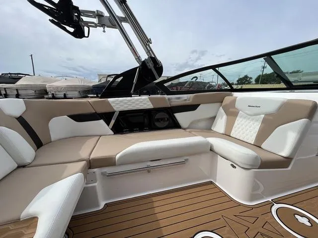 Slide: The Image of 2024 MasterCraft XT20 boat interior with beige and white seating, featuring sleek design and modern amenities. - 23
